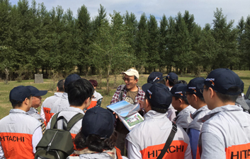 NGO组织大泷隆司为参观者介绍日立建机已经培育成功的第一个绿化林地