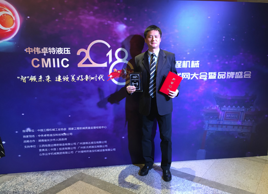 图片：日立建机(上海)有限公司营业本部徐昊部长展示证书和奖牌